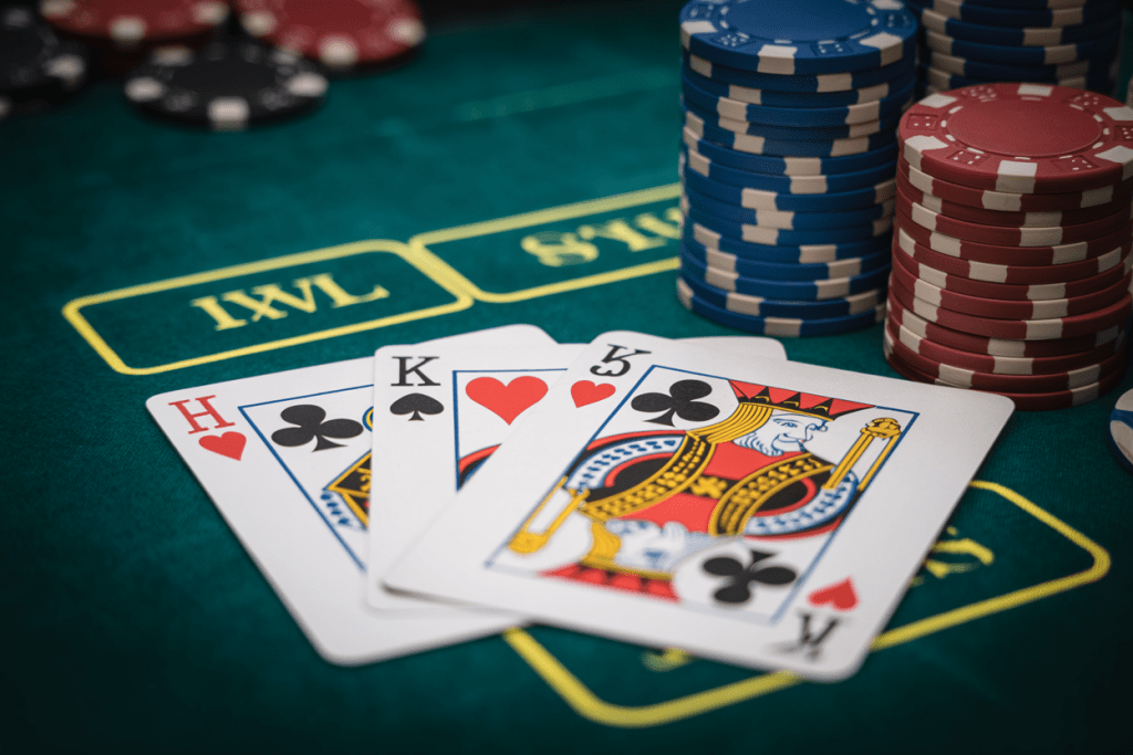 카지노 테이블 위에 칩과 함께 펼쳐진 K·H·K 카드 조합이 클로즈업으로 보이는 장면.